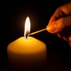 Hand lighting candle